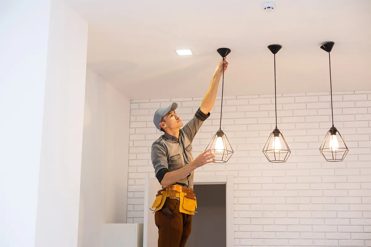 A Mr. Bright Electric electrician installs new kitchen lights in a home