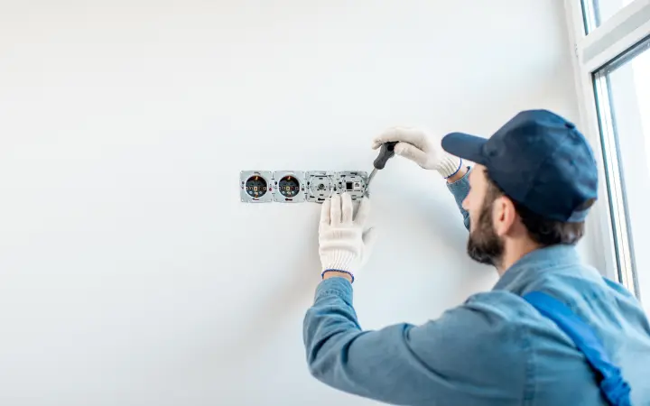 Electrician installing electrical sockets in the wall of a residential home in Woodland